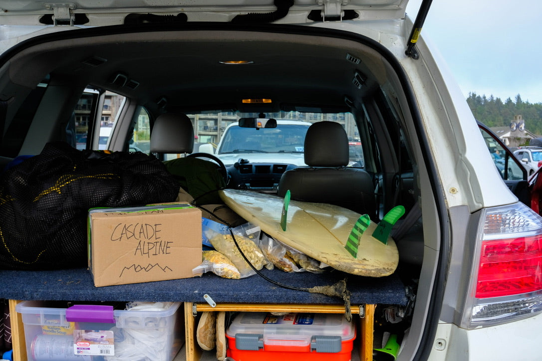 The back of a loaded 4Runner with a Cascade Alpine box, a surfboard and a week of meals